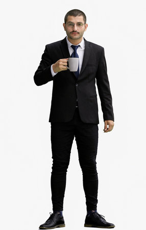 young man in full growth. isolated on white background. holding a mug of coffeeの写真素材