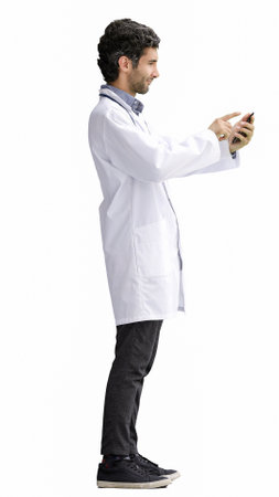 male doctor in a white coat on a white background speaks on the phoneの写真素材