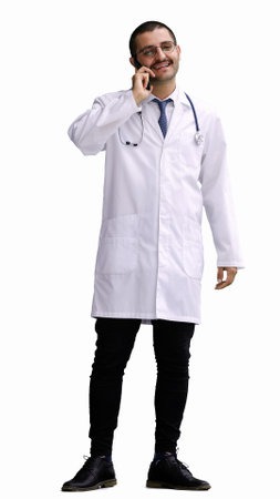 male doctor in a white coat on a white background speaks on the phoneの写真素材