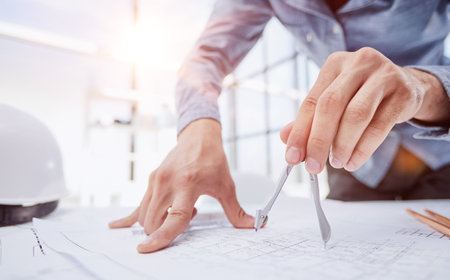 Architect working on drawing table in officeの写真素材