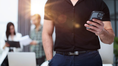 Close-up of a smartphone screen in the hands of a businessman.の写真素材