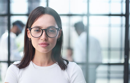 business woman with her staff in background at office