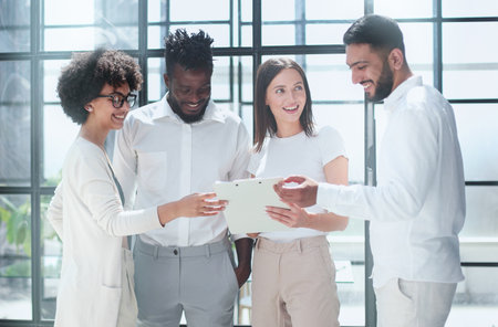 Employees working at computer together, discussing content
