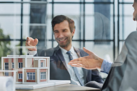 two successful people are discussing a house construction project. layout on the tableの写真素材
