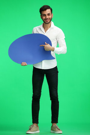 full-length man on a green background holding a sign commentの写真素材