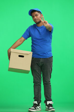 A man on a green background with box show a victory signの写真素材