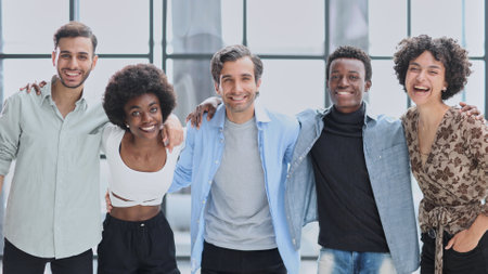 a group of successful business diverse people in the office stands embracingの写真素材