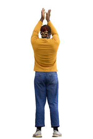 A man in a yellow jacket on White background raised his hands up and rejoices, back view