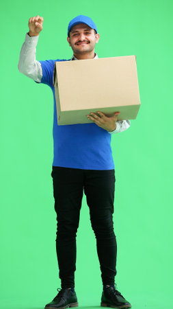 full-length male courier holding a box on a green backgroundの写真素材