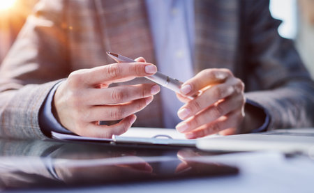 Holding pen in hand. Signing legal document. Businessman signing contract at tableの写真素材