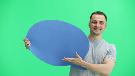 A man in a gray T-shirt, on a green background, close-up, with a blue comment markの写真素材