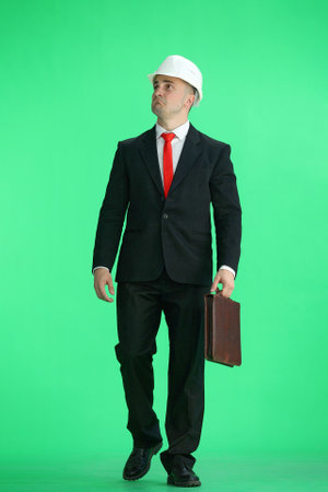 Foreman, on a green background, full-length, with a briefcaseの写真素材