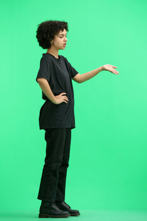 A woman, full-length, on a green background, talkingの写真素材
