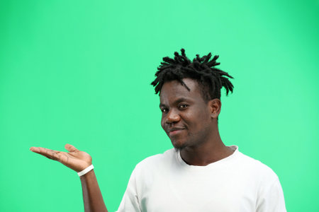 A man, close-up, on a green background, points to the sideの写真素材