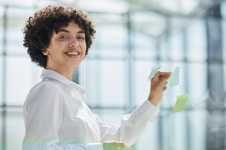 woman working on project plan using sticky papers notes on glass