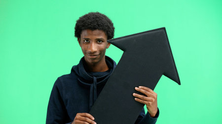 Man, close-up, on a green background, pointing up arrowの写真素材