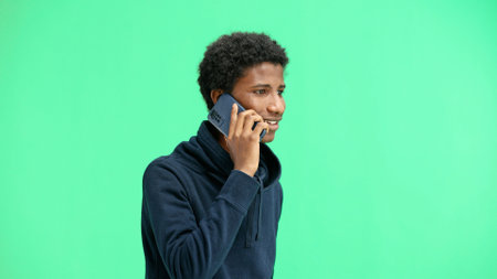 Man, close-up, on a green background, talking on the phoneの写真素材