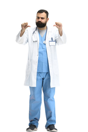 A male doctor, full-length, on a white background, shows his thumbs downの写真素材