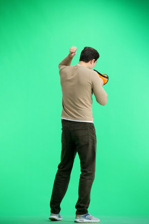 A man, full-length, on a green background, with a megaphoneの写真素材