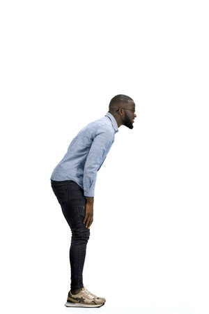 A man, full-length, on a white background, rubs his hands