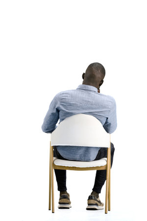A man, on a white background, sitting on a chairの写真素材
