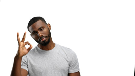 A man, close-up, on a white background, shows an ok sign