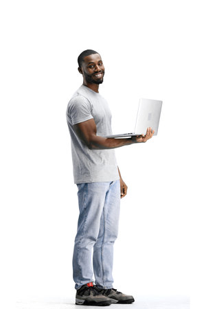 A man, full-length, on a white background, uses a laptop