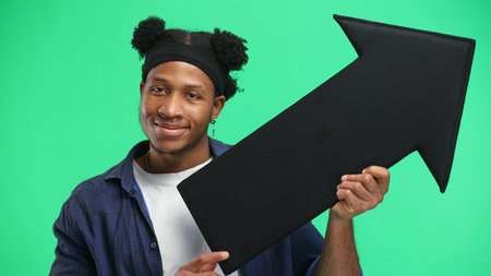 A man, close-up, on a green background, points an arrow to the side