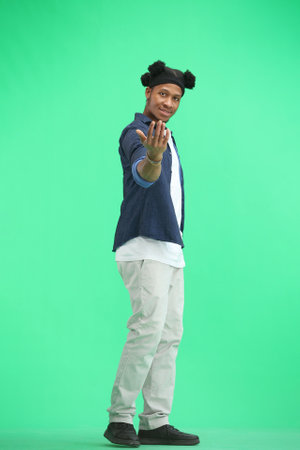 A man, full-length, on a green background, calls to him