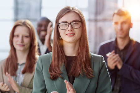 Portrait of a young serious business woman with colleagues
