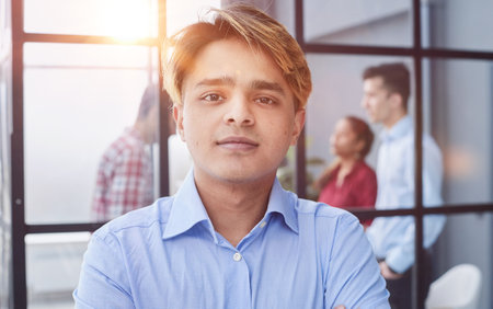 Portrait of a man in a blue shirt looking at the camera.