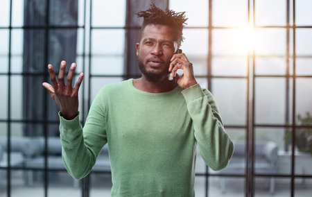 Modern young man with mobile phone in the office.
