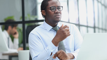 portrait of a man at his workplace at the table in front of the computer smiling