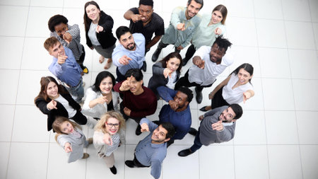 multicultural successful business group looking up in office corridor