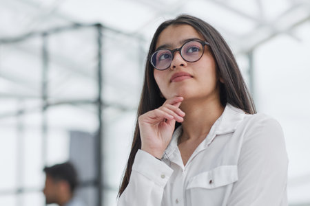 a girl stands in a modern office and looks at the cameraの写真素材