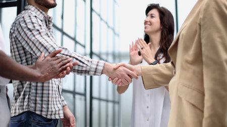 A group of business people hang out together during a coffee break in the hallway of a large corporationの写真素材