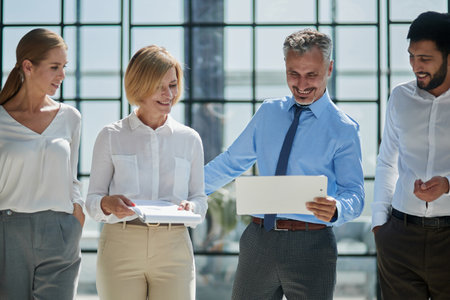 Office routine. Female assistant manager discussing statistics with male chief executive officer.の写真素材