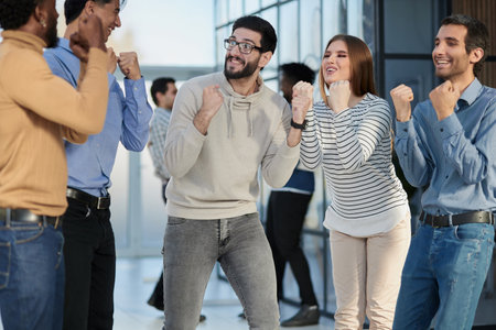 Business people celebrates and clench their fists in the air as a winning teamの写真素材