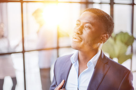 Head shot close up young thoughtful african american businessman entrepreneur looking away.の写真素材