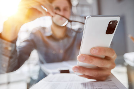 businessman professional executive holding mobile working at desk with smartphone.の写真素材