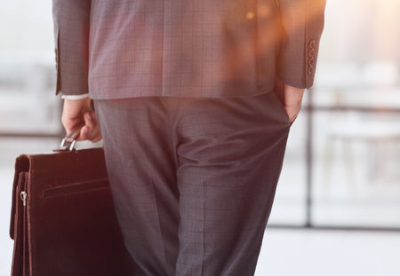 business man with briefcase in office back viewの写真素材