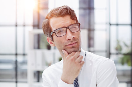 Pensive businessman in a modern office, close-upの写真素材