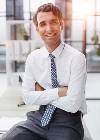 Businessman sitting on the table and looking at the cameraの写真素材