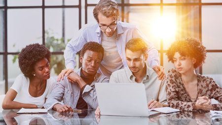 Employees working at computer together, discussing contentの写真素材