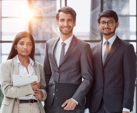 a team of three people stands in a modern officeの写真素材