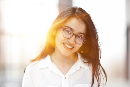 A close up head shot portrait of a preppy, young, beautiful, confident and attractive womanの写真素材