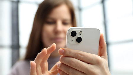 A woman in close-up in the office working and using the phoneの写真素材