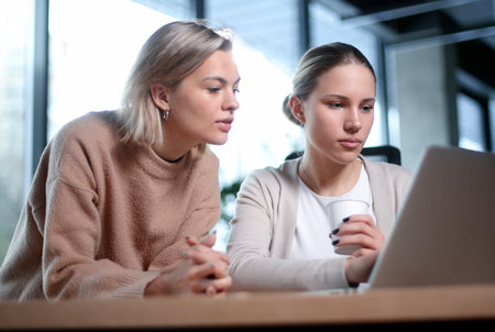 Two women are looking at a laptop togetherの写真素材