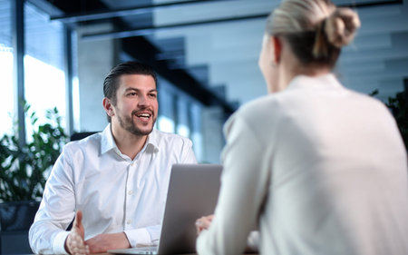 A man and a woman are sitting at a table talkingの写真素材