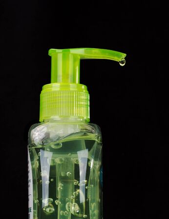 Aloe vera hand sanitiser with a drop from nozzle on isolated black backgroundの写真素材